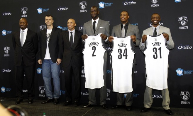 Newly acquired Net's Pierce, Garnett and Terry hold up their new jerseys as they pose for a photo with the NBA team's principal owner Prokhorov, general manager King and head coach Kidd in Brooklyn