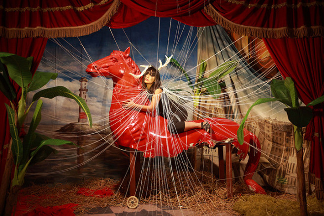 A woman on horse surrounded by threads