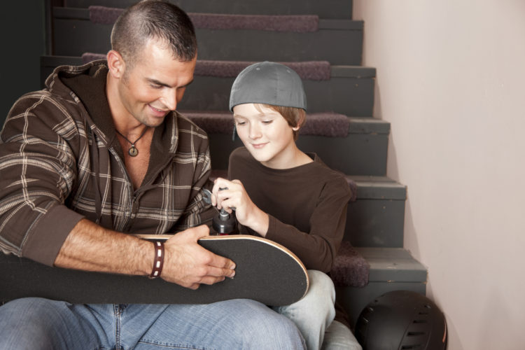 Young Adult Man Helping Adolescent Boy with Fishing Equipment