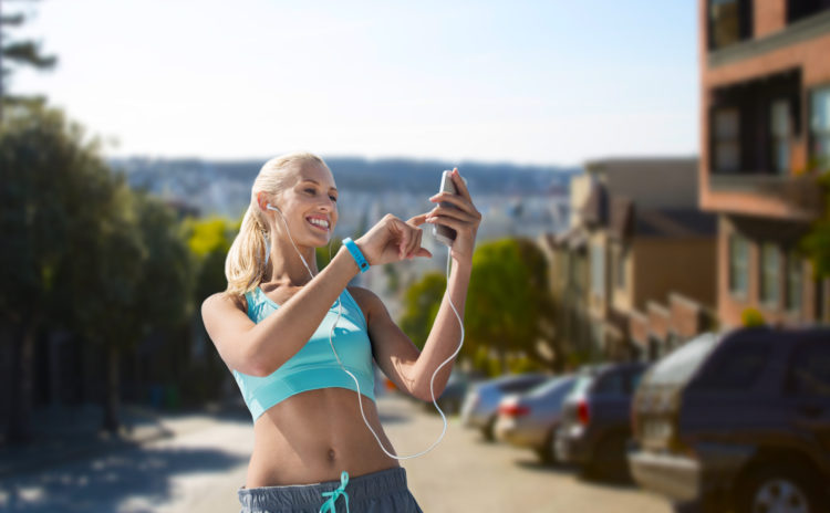 woman with smartphone and earphones doing sports