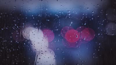 stock-footage-rainy-days-rain-drops-on-the-window-with-traffic-light-blur