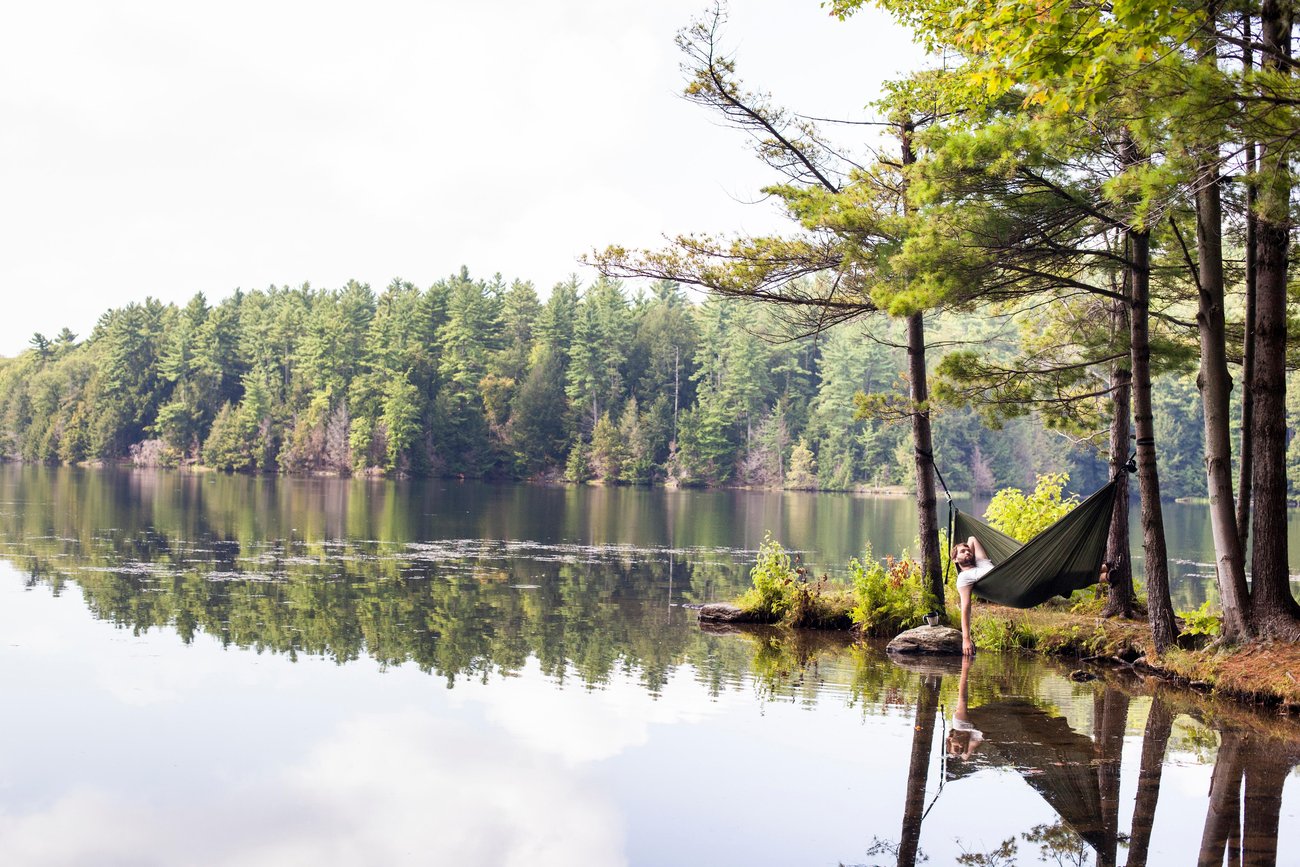 A young man, Judd Lamphere, rests in a hammock along Indian Brook Reservoir in Essex, Vermont.