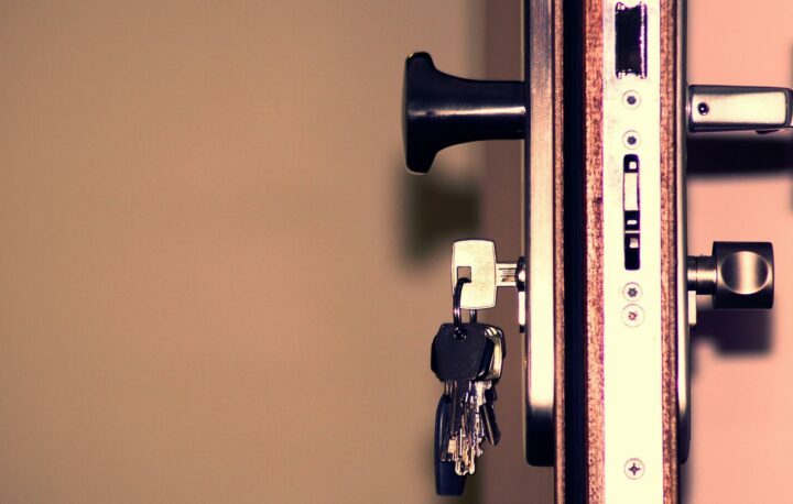 插著鑰匙的房門特寫，呈現回家與安全感的意象