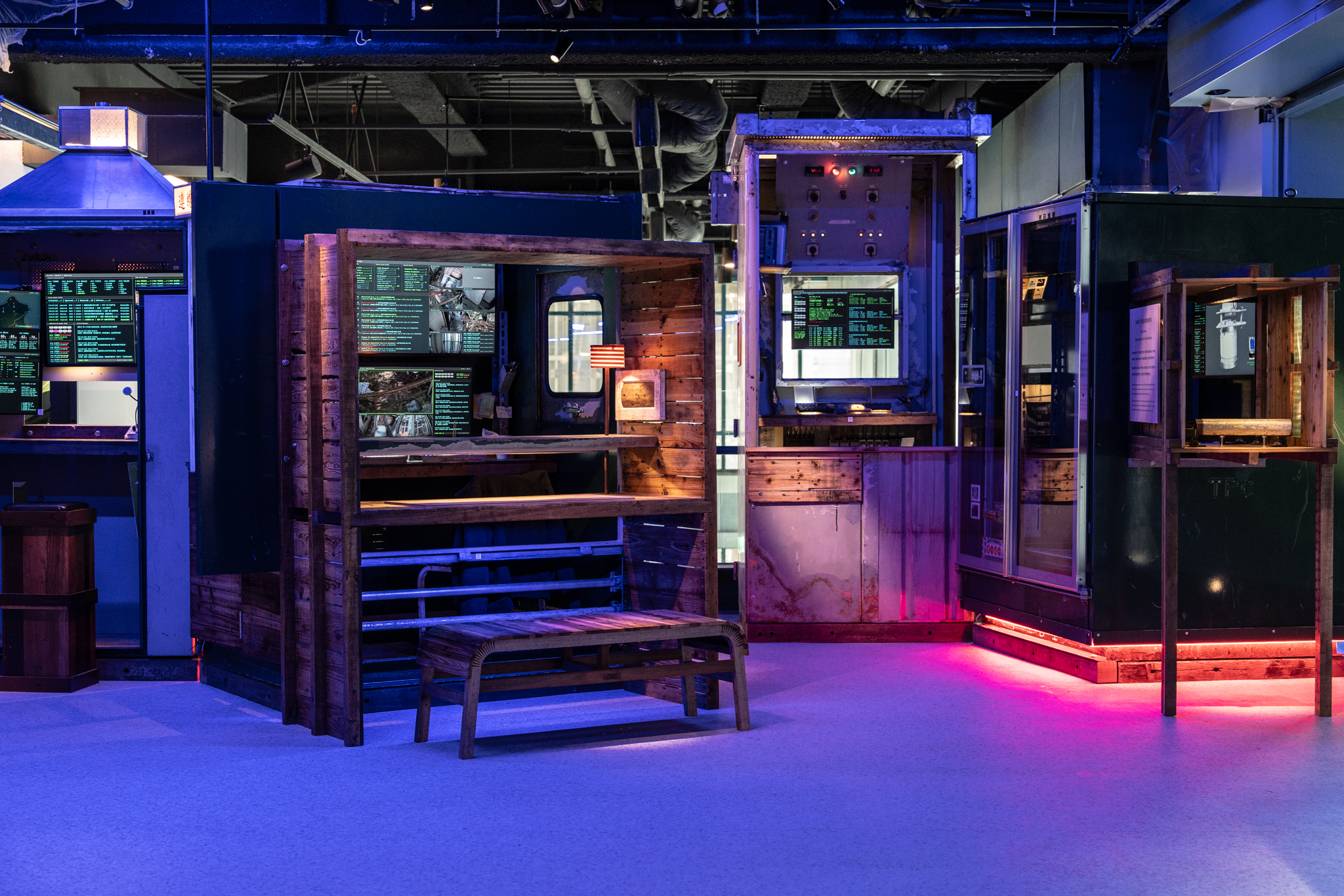 展示未來小屋設計的互動展覽場景，包括具有數位屏幕和木製結構的設計。